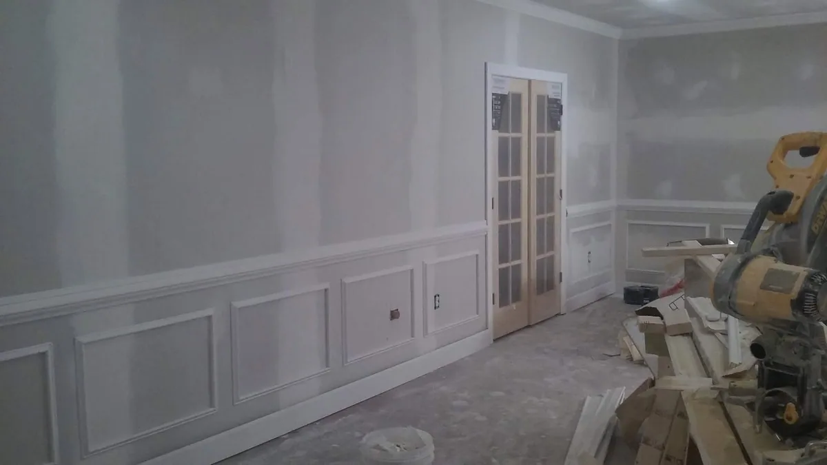 Basement finish carpentry in progress with paneled trim and French doors