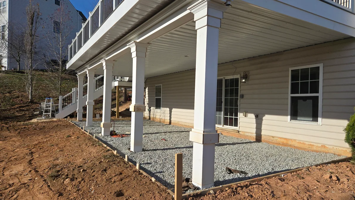Covered patio area being prepared beneath an elevated deck