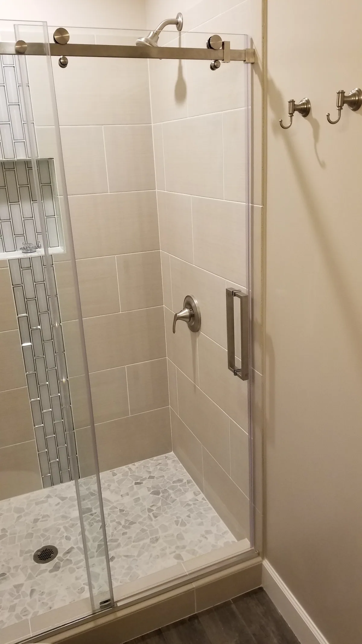 Finished tiled shower with sliding glass door and brushed nickel hardware